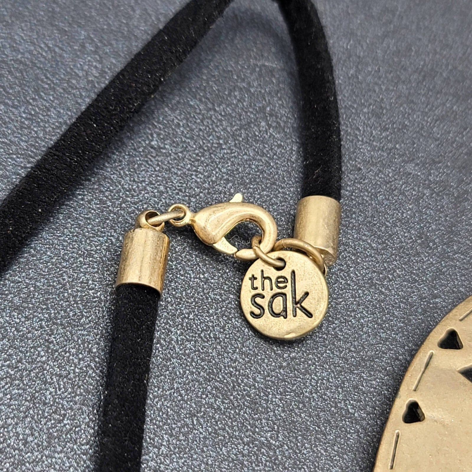 The Sak Necklace Gold tone Pendant Black Faux Leather Cord 28"